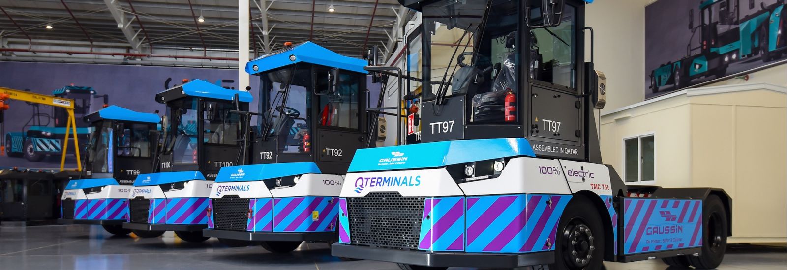 Gaussin logsitics equipment, bright blue, black, and white in color, lined up in a row