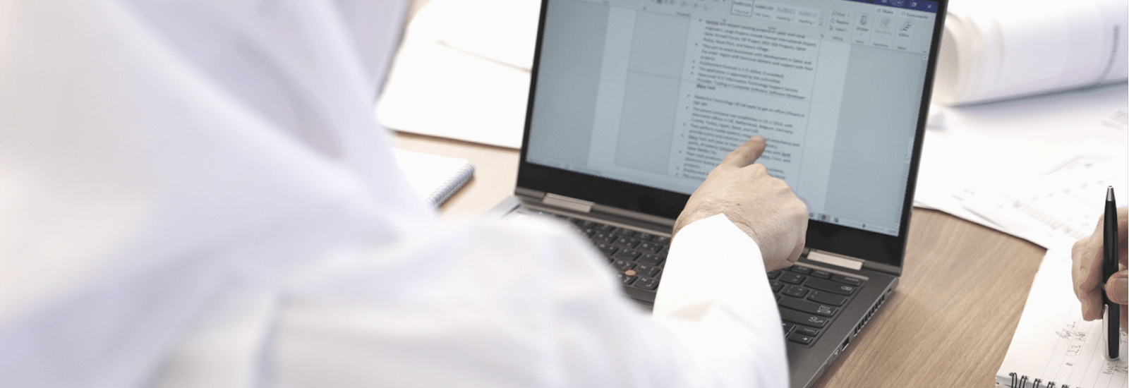 Close up of person pointing at a computer screen