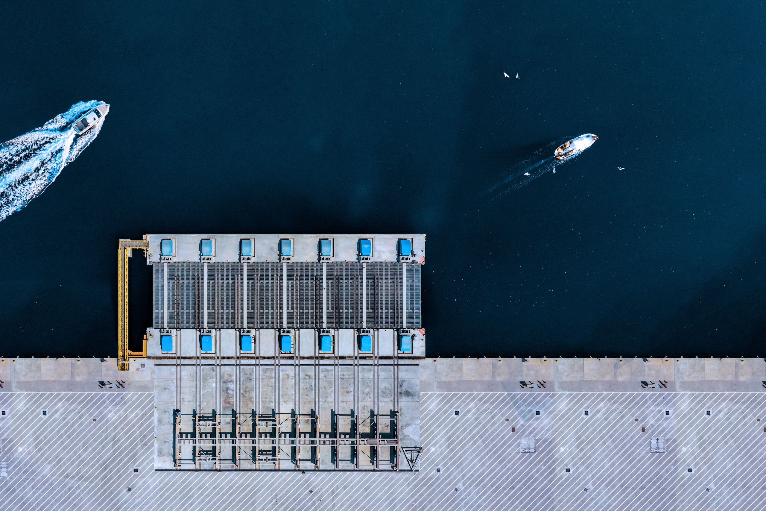 Aerial View of dock, with boats driving by